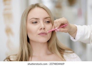 Lips  makeup, stylish visagist doing lip outline using pencil - Powered by Shutterstock