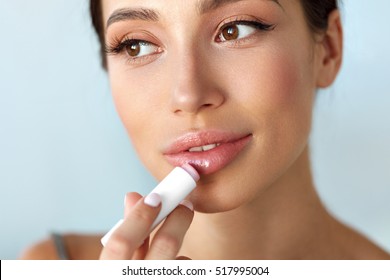 Lips Protection. Beautiful Woman With Beauty Face, Sexy Full Lips Applying Lip Balm, Lipcare Stick On. Portrait Of Female Model With Natural Makeup. Lips Skin Care Cosmetics Concept. High Resolution