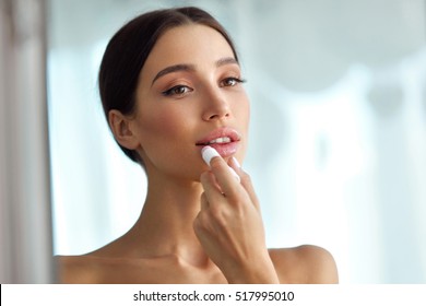 Lips Protection. Beautiful Woman With Beauty Face, Sexy Full Lips Applying Lip Balm, Lipcare Stick On. Portrait Of Female Model With Natural Makeup. Lips Skin Care Cosmetics Concept. High Resolution