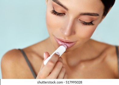 Lips Skin Care Cosmetics. Beautiful Woman With Beauty Face, Sexy Full Lips Applying Lip Balm, Lipcare Stick On. Portrait Of Model Girl With Natural Makeup Putting Hygienic Lipstick On. High Resolution