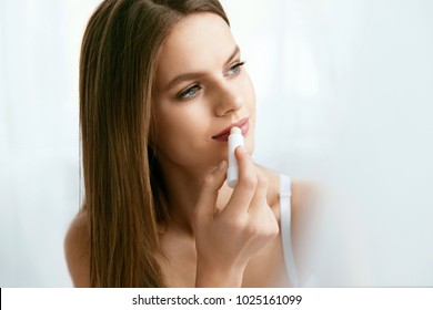 Lips Skin Care. Female Applying Hygienic Lip Balm. Portrait Of Beautiful Woman With Beauty Face And Healthy Soft Smooth Skin Putting Hygienic Lipstick. Lips Protection. High Resolution.