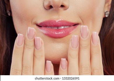 Lips with trendy color glossy lipgloss makeup. Beautiful female mouth and perfect manicured nails