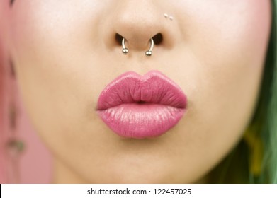 Lips of young woman wearing pink lipstick