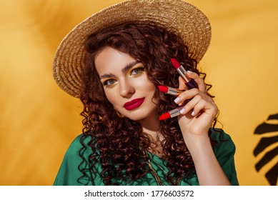 Lipstick Advertising Conception: Beautiful Woman With Bold Fuchsia Color Lips Makeup Holding Three Lipsticks. Summer Make Up