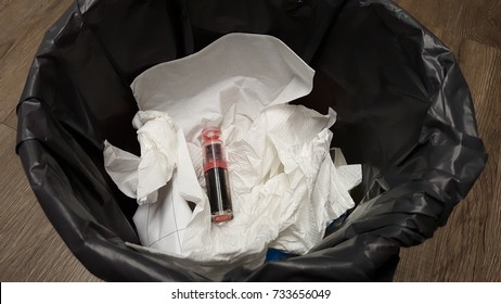 Lipstick. Pink Lipstick Throw Away In Plastic Black Bag In Litter Bin With Tissue And Paper Background. Beauty Product Expiration Concept.