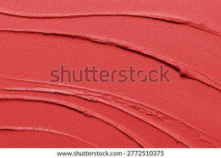 Lipstick texture background. Matte red creamy makeup product smudged close up