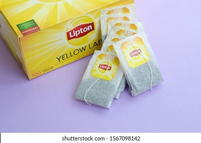 Lipton Yellow Label black tea pack and teabags on pastel lilac surface close up. Lipton is a world famous brand of tea