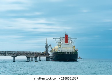 liquefied natural gas carrier tanker during loading at an LNG offshore terminal, in the distance the oil export terminal is visible in the sea - Shutterstock ID 2188531569