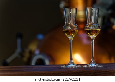 Liqueur Glasses In Front Of A Gin Distiller.