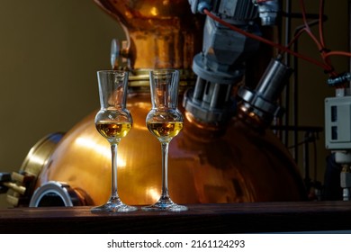 Liqueur Glasses In Front Of A Gin Distiller.