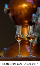 Liqueur Glasses In Front Of A Gin Distiller.