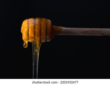 Liquid Amber Honey Dripping From Spoon Or Honey Dipper