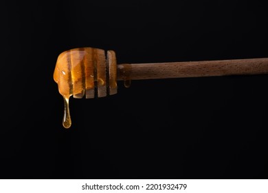 Liquid Amber Honey Dripping From Spoon Or Honey Dipper