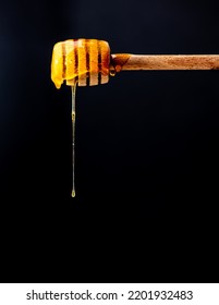 Liquid Amber Honey Dripping From Spoon Or Honey Dipper