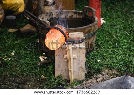 Liquid bronze heated to 1200°C is poured into a mould. Casting bronze jewelry,  Experimental Archaeometallurgy. Viking Metal Casting. Bronze Age Forging. The lost-wax method, charcoal-fired hearth.