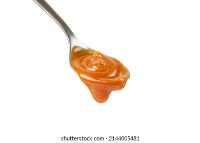 Liquid Caramel On Spoon. Caramel Drips From The Spoon. Pouring Sweet Sauce. Texture, Close Up.