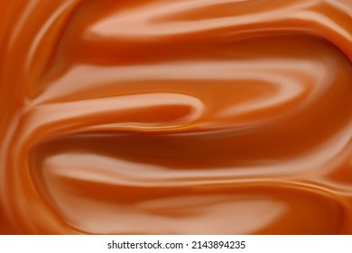 Liquid caramel syrup. Background of caramel paste. Curl of caramel. Texture Close up, top view.