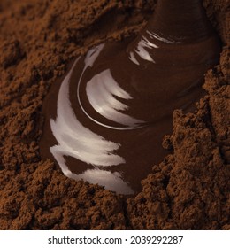Liquid Chocolate flowing over chocolate cocoa powder