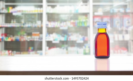 Liquid Drug Syrup Bottle On Shelf In Pharmacy Store 