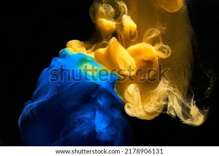 Liquid fluid art abstract background. Blue yellow dancing acrylic paints underwater, ocean space smoke