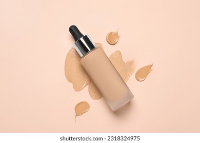 Liquid foundation and swatches on beige background, top view
