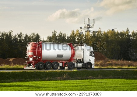 Liquid Fuel and Oil Cargo Semi Truck on the Highway. Compressed Gas Carrier Truck in the Evening Light. Hauling Petroleum Products. Oil Cargo Truck Hauling Petroleum Products.
