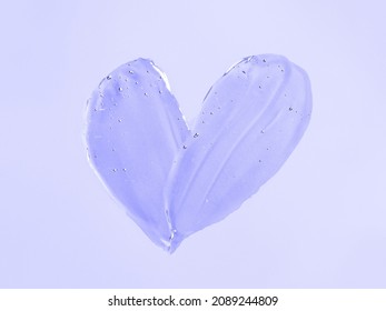 Kosmetische Muschelstruktur mit flüssigem Gel in Herzform auf violettem oder violettem Hintergrund. Ästhetisch schön strukturiert verschmiert transparentes Hautgel oder Gesichtsmaske wie Herz. Vorführung der Farbe des Jahres 2022