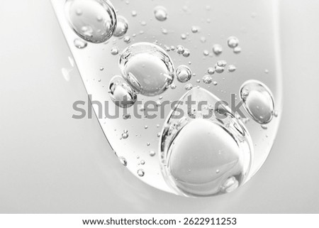Liquid gel flows down from a transparent surface, macro, beauty background.