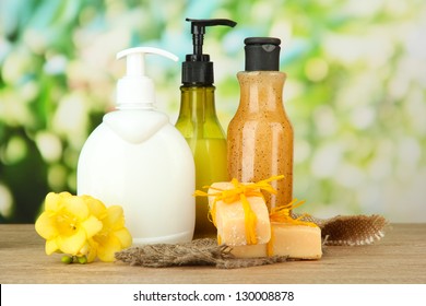 Liquid And Hand-made Soaps On Wooden Table, On Green Background