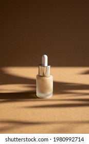 Liquid Makeup Foundation In Glass Bottle On Brown Background With Dark Shadows , Modern Mock Up Concept Sidr View