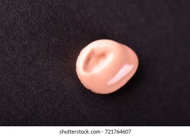 Liquid makeup foundations smear drop on black background.