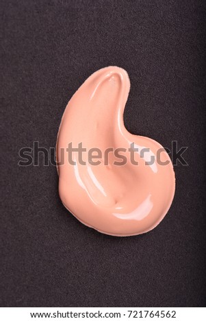 Liquid makeup foundations smear drop on black background.