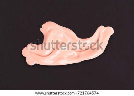 Liquid makeup foundations smear drop on black background.