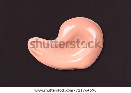 Liquid makeup foundations smear drop on black background.