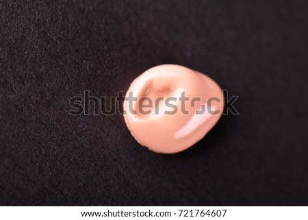 Liquid makeup foundations smear drop on black background.
