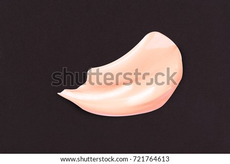 Liquid makeup foundations smear drop on black background.
