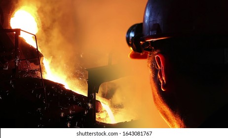 Liquid Metal In The Foundry, Melting Iron In Furnace, Steel Mill. Worker With Goggles And Helmet Controlling Iron Smelting In Furnaces, Applying Heat To Ore In Order To Extract A Base Metal