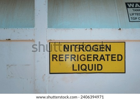 Liquid nitrogen storage tank with English text label for logistic transportation. Industrial equipment with symbol object photo, selective focus.