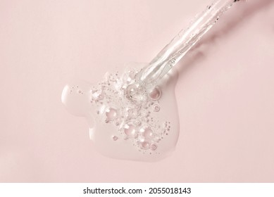 Liquid oil serum drop in pipette isolated on pastel pink background. Retinol, aha, bha acid, collagen skincare fluid, photo with shallow depth of field. Gold essence in dropper for beauty treatment. - Shutterstock ID 2055018143