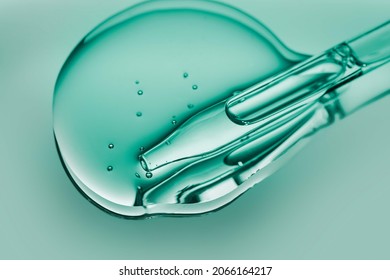 Liquid pipette oil or serum elixir cool emerald green on light green colored mirror background - Shutterstock ID 2066164217