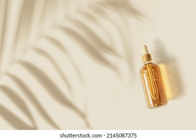 Liquid Product Packaging In Glass Bottle On Pastel Beige Background And Palm Leaf Shadow. Hyaluronic Or Polyglutamic Acid Oil Cosmetic Mock Up. Facial Cosmetics, Minimal Aesthetic Trend, Top View