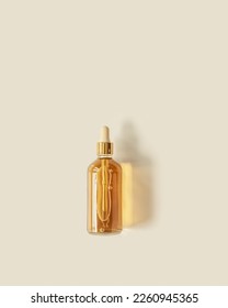 Liquid product packaging in glass bottle on pastel beige background and  beautiful shadow. Hyaluronic or polyglutamic acid oil cosmetic mock up. Facial cosmetics, minimal aesthetic trend, top view - Shutterstock ID 2260945365