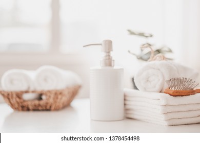 Liquid soap bottle, white towel on basket in bathroom. Hygiene and healthy life concept. Close up, selective focus