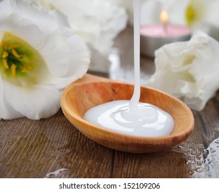 Liquid Soap And White Flowers On A Brown Background