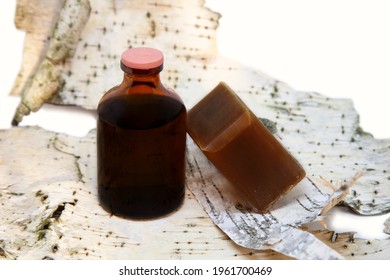 Liquid Tar In A Bottle And A Piece Of Tar Soap On Birch Bark Background