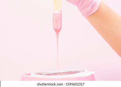 liquid wax for pink depilation drains from the stick. The concept of depilation, waxing, smooth skin without hair. - Shutterstock ID 1595651317