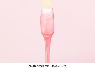 Liquid Wax For Pink Depilation Drains From The Stick. The Concept Of Depilation, Waxing, Smooth Skin Without Hair.