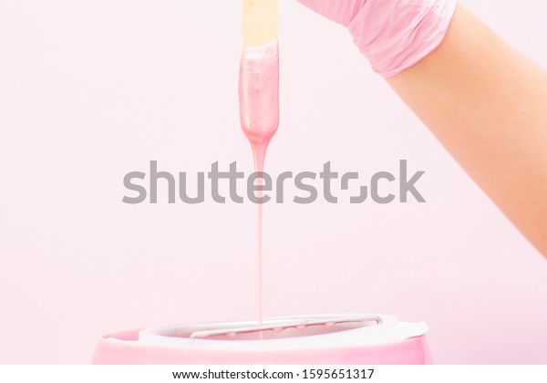 liquid wax\
for pink depilation drains from the stick. The concept of\
depilation, waxing, smooth skin without\
hair.