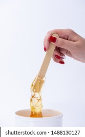 Liquid Yellow Sugar Paste Or Wax For Depilation On A Wooden Stick Close-up On A White Background