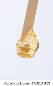 Liquid Yellow Sugar Paste Or Wax For Depilation On A Wooden Stick Close-up On A White Background